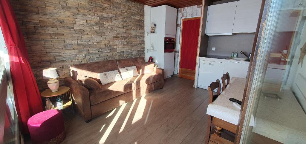 un salon avec un canapé et une cuisine dans l'établissement Le Serac W6 appartement avec véranda en angle vue panoramique gérer par particulier sur place, à Val Thorens