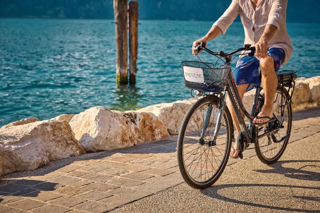 Un homme à vélo près de l'eau dans l'établissement Lake Front Hotel Brenzone, à Brenzone