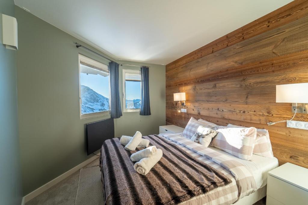 une chambre avec un grand lit avec un mur en bois dans l'établissement Chalet Sapin by Avoriaz Chalets, à Avoriaz 37 autres photos