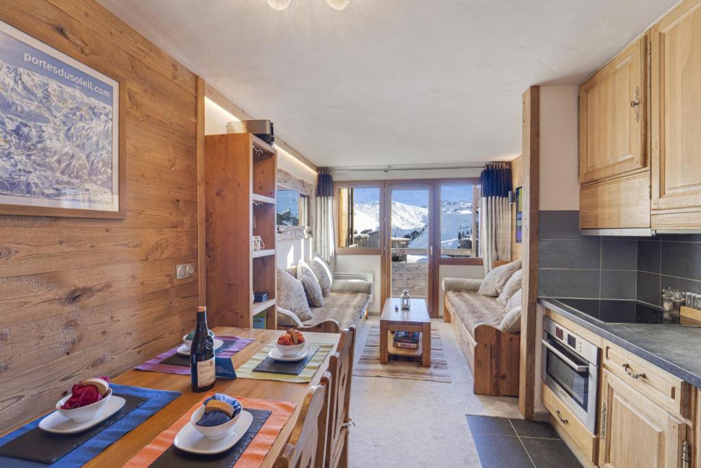 une cuisine et un salon avec une table et un canapé dans l'établissement Chalet Chamois - central modern Duplex for 6 by Avoriaz Chalets, à Avoriaz