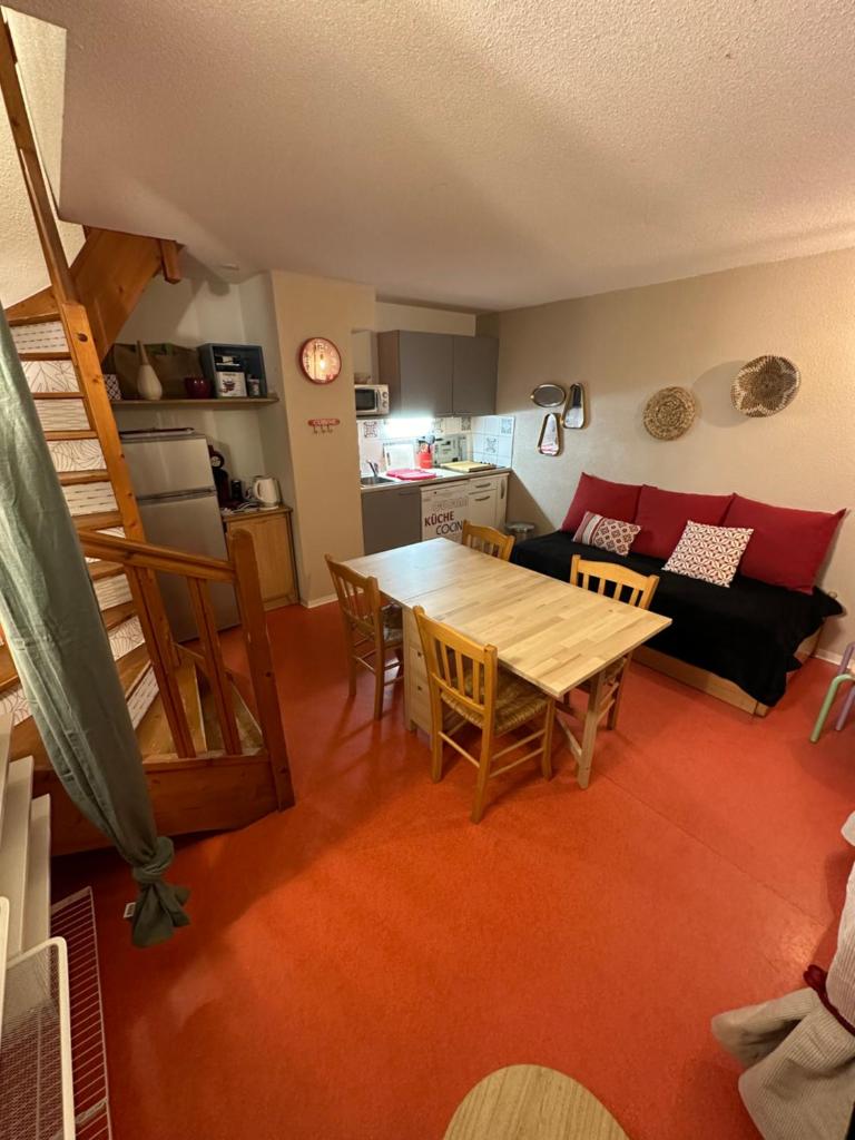 un salon avec une table et un canapé dans l'établissement Appartement de 32m² au cœur de la Joue du Loup, à Saint-Étienne-en-Dévoluy