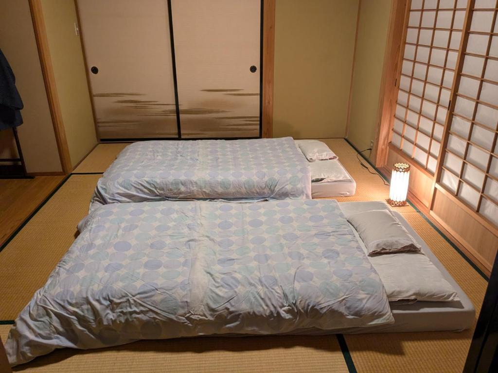 deux lits jumeaux dans une chambre avec dans l'établissement 縁の宿 北堀, à Matsue