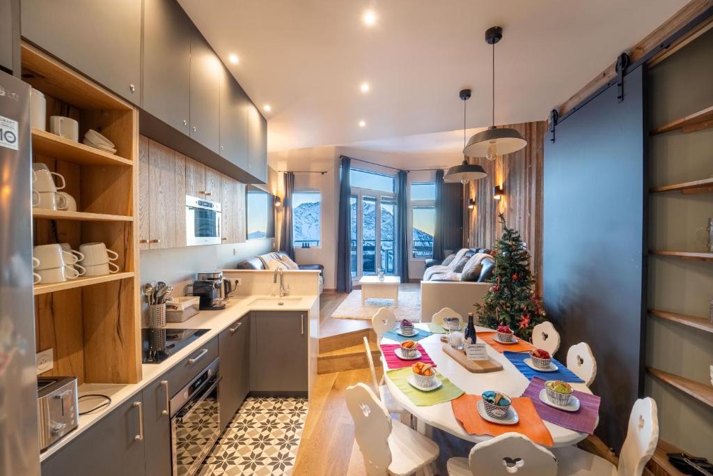 une cuisine et un salon avec une table et un arbre de Noël dans l'établissement Chalet Sapin by Avoriaz Chalets, à Avoriaz