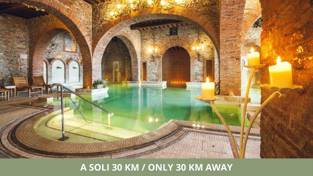 - une piscine dans un vieux bâtiment avec bougies dans l'établissement CSA Hotel Beach & Park, à Marina di Bibbona