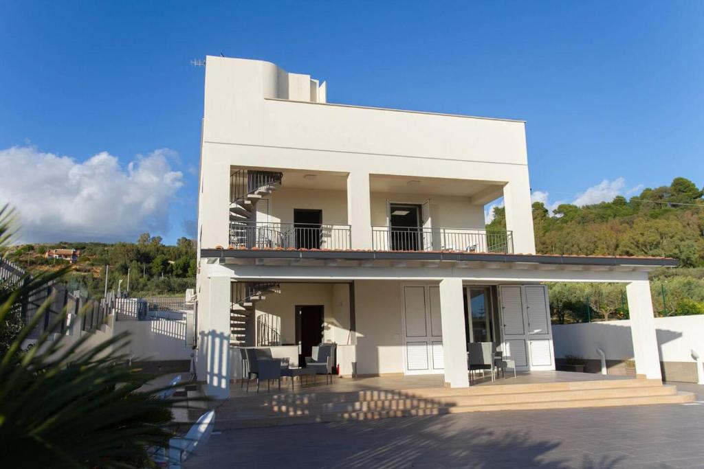 Cette maison blanche dispose d'un balcon sur le côté. dans l'établissement Villa San Giorgio Sciacca, à Sciacca