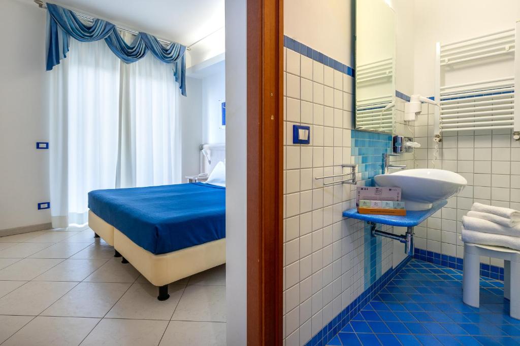 une salle de bain avec un lit et un lavabo dans une chambre dans l'établissement Elaia Garden Hotel, à Sperlonga 44 autres photos
