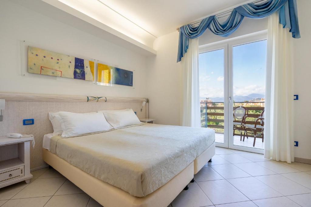 une chambre avec un lit et une grande fenêtre dans l'établissement Elaia Garden Hotel, à Sperlonga