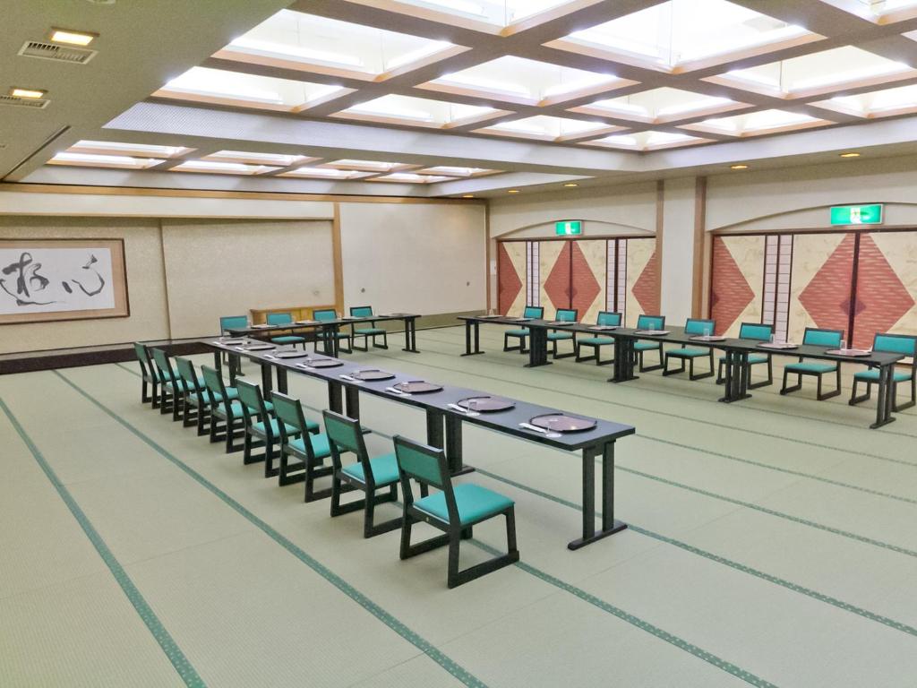 une grande chambre avec des tables et des chaises. dans l'établissement 赤湯温泉 丹泉ホテル, à Nanyo 33 autres photos