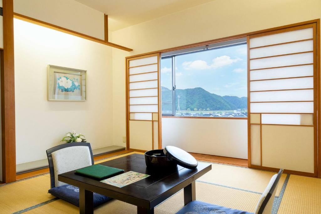 une salle à manger avec une table et une fenêtre dans l'établissement Suizansou, à Toyooka
