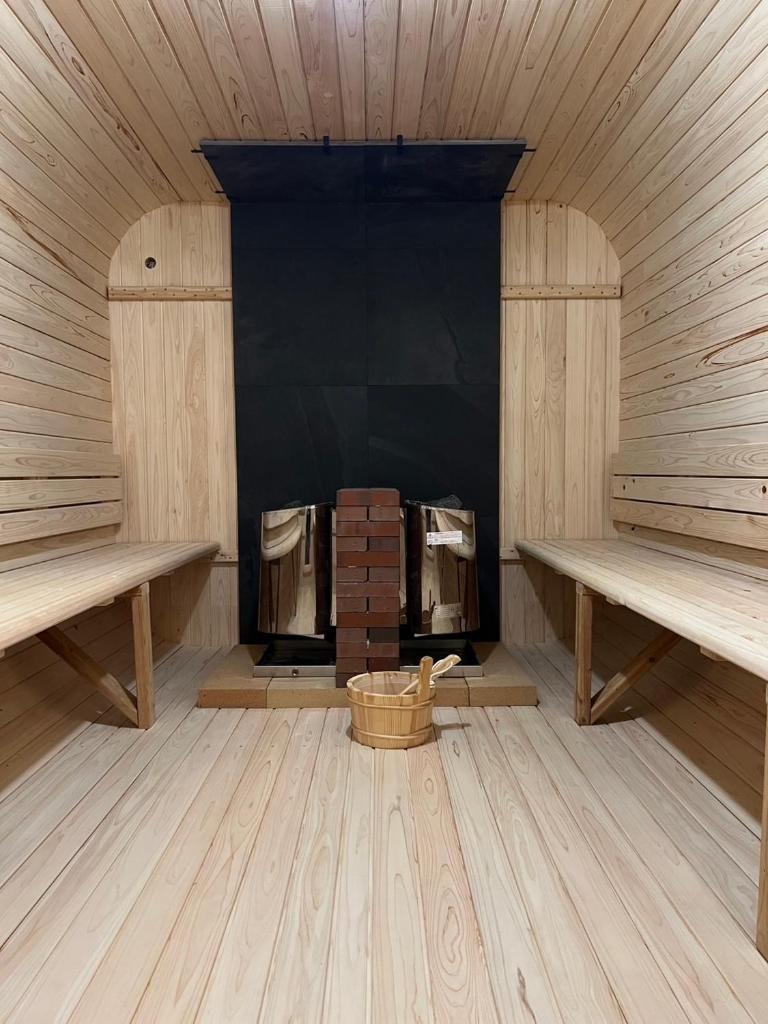 Cette chambre dispose d'un poêle à bois avec deux bancs. dans l'établissement Hotel 螢月ｰhozukiｰ Adult Only, à Sendai
