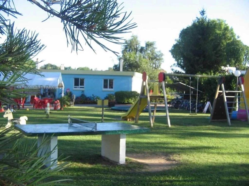 un parc avec une aire de jeux avec un toboggan et des balançoires dans l'établissement Camping 4 étoiles - Piscine - efcfbi, à Faverolles-sur-Cher