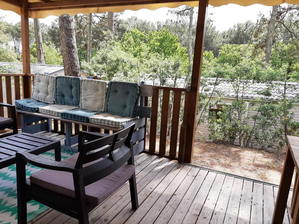 - une véranda avec un canapé et des chaises dans l'établissement Mobilhome Mobil home Cap ferret, à Claouey