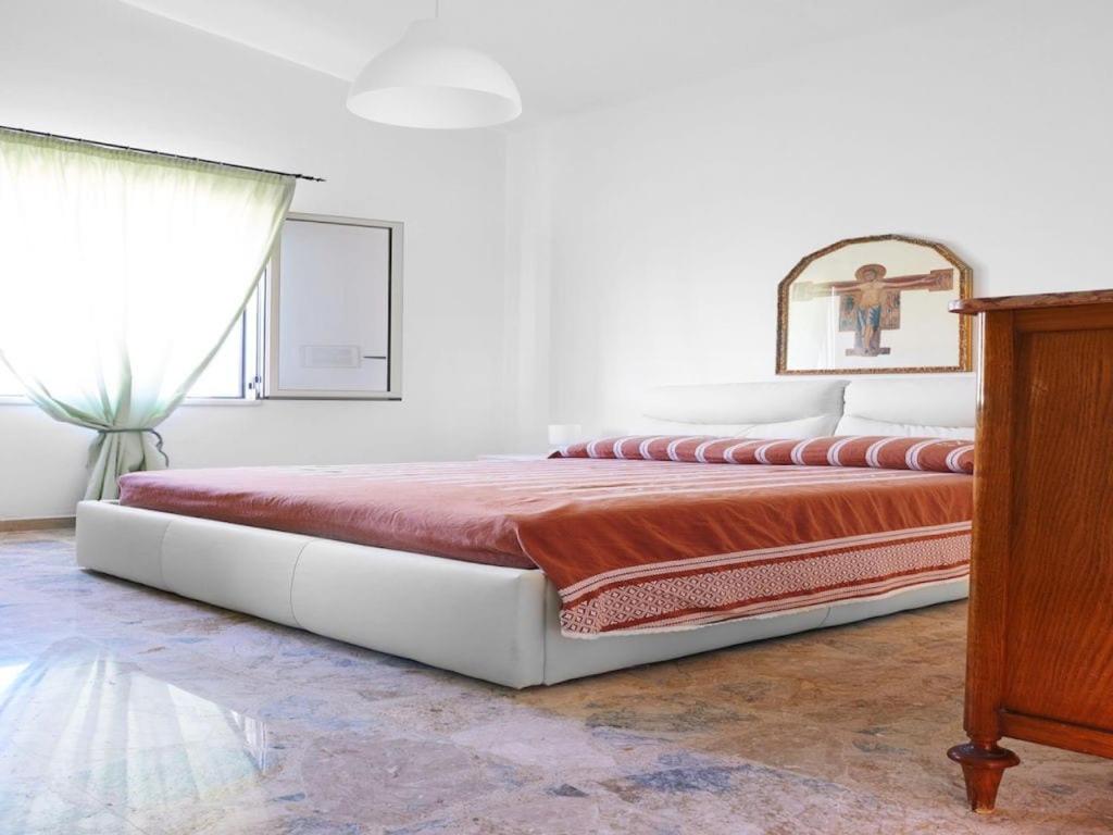 Cette chambre blanche dispose d'un grand lit et d'une fenêtre. dans l'établissement Villa Le Terrazze Blu by Sicily Travelling Villas, à Castellammare del Golfo