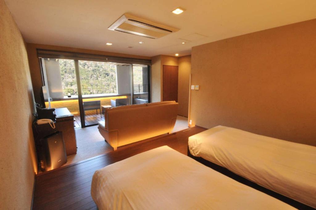une chambre d'hôtel avec deux lits et un canapé dans l'établissement Aura Tachibana, à Hakone