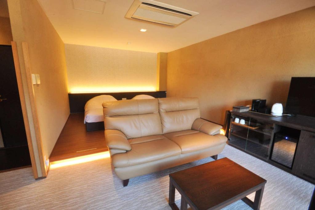 un salon avec un canapé et un lit dans l'établissement Aura Tachibana, à Hakone