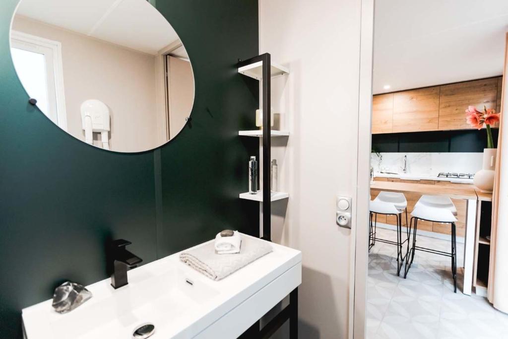 une salle de bain avec un lavabo blanc et un miroir dans l'établissement Camping Country Park Touquin - Site Officiel - Next to Disneyland Paris, à Touquin