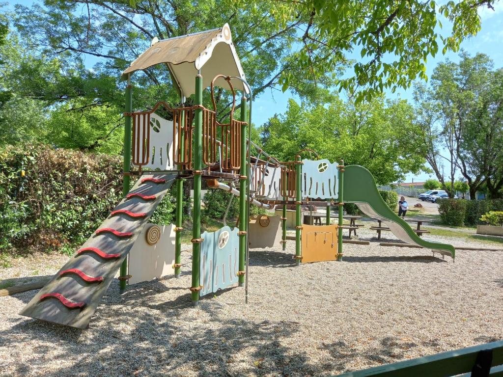 une aire de jeux avec un toboggan dans un parc dans l'établissement camping le Faillal, à Montpezat-de-Quercy