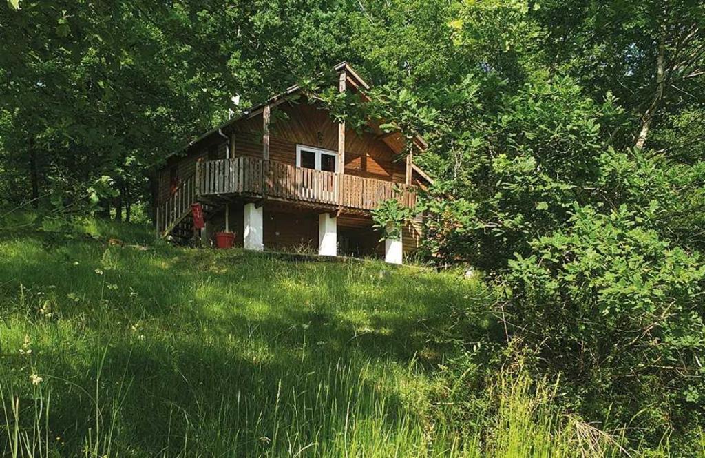 une cabane en rondins sur une colline dans un champ d'herbe dans l'établissement Camping 4 étoiles - Parc aquatique - eee0ic, à Salles