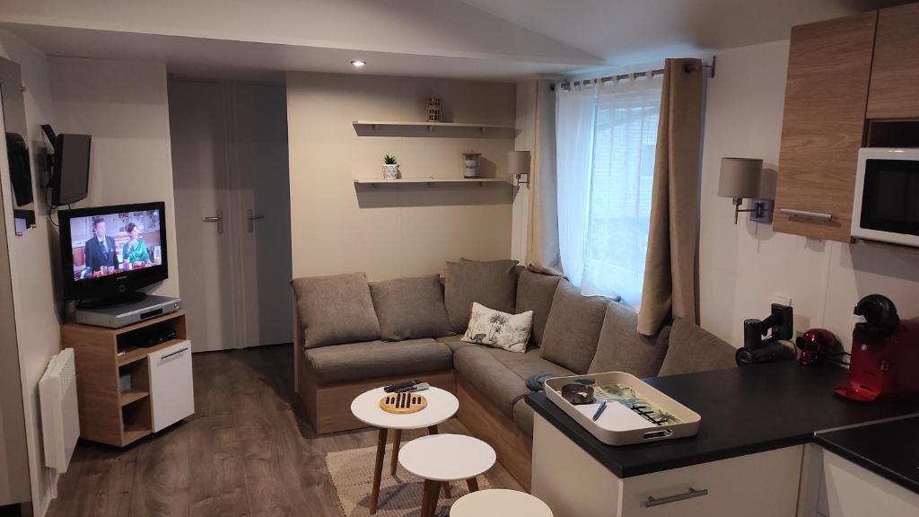 un petit salon avec un canapé et une table dans l'établissement MOBILHOME Soulac, à Soulac-sur-Mer