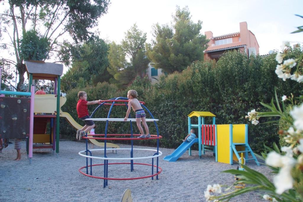 un groupe d'enfants jouant sur une aire de jeux dans l'établissement Camping de la Baie, à Cavalaire-sur-Mer