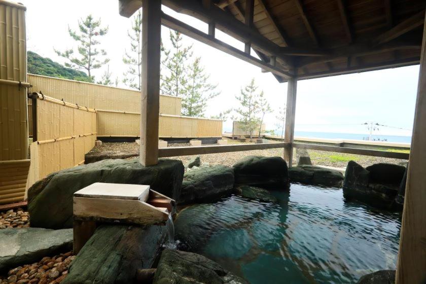 - une grande piscine d'eau dans un bâtiment avec des rochers dans l'établissement Kameya Hotel, à Tsuruoka
