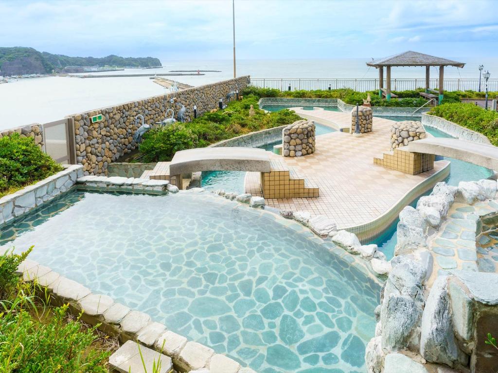 une piscine dans un complexe avec l'océan en arrière-plan dans l'établissement Mikazuki Sea-Park Hotel Katsuura, à Katsuura