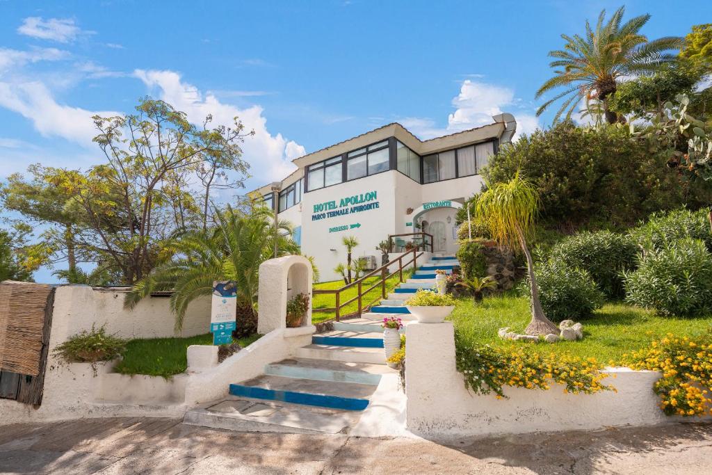 un bâtiment avec des escaliers bleus en face dans l'établissement Apollon Club & Thermal Spa, à Ischia