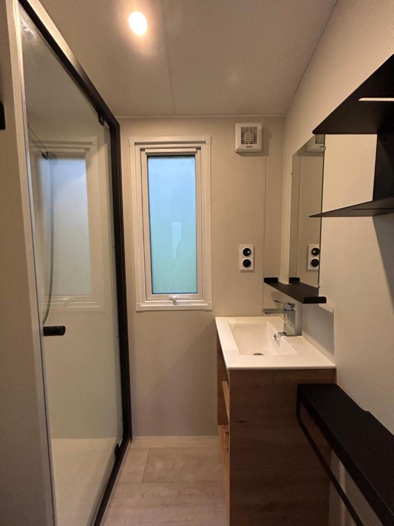 une salle de bain avec un lavabo et une fenêtre dans l'établissement Camping du Valentin, à Laruns