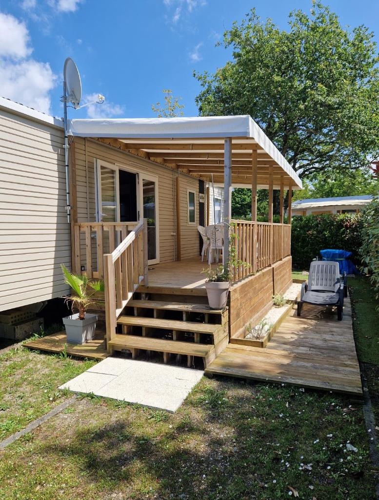 une petite cabine avec une terrasse couverte et une terrasse dans l'établissement Mobilehome familial, à Gastes