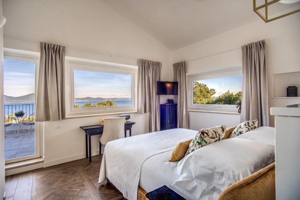 une chambre avec un lit et deux fenêtres dans l'établissement Vigna Caio Relais & Spa, à Bracciano