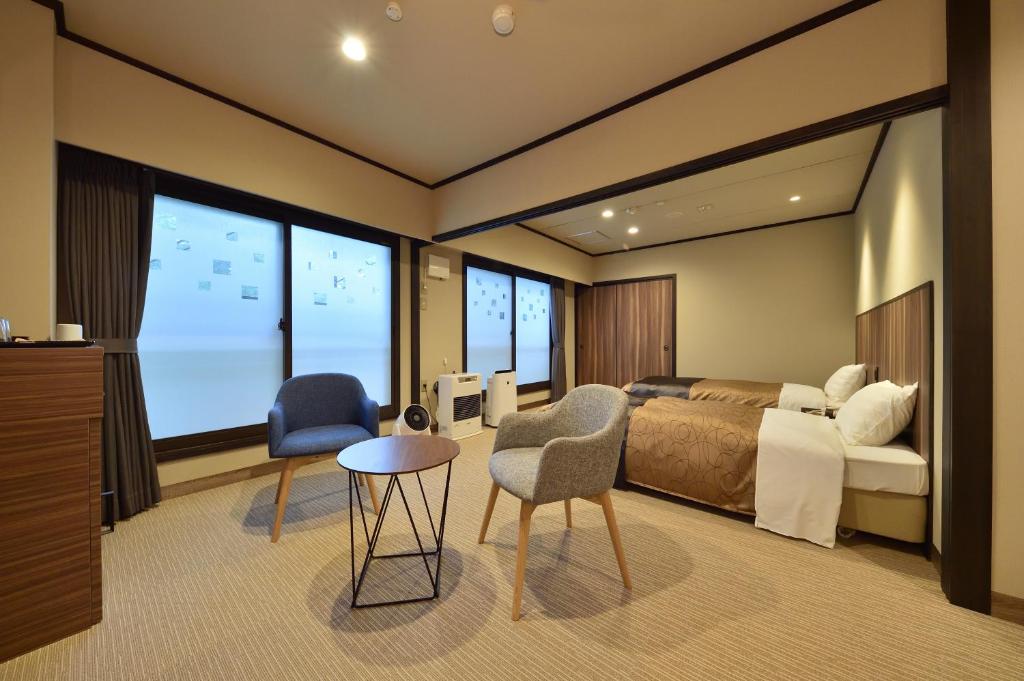 une chambre d'hôtel avec un lit et une grande fenêtre dans l'établissement 碧の美ゆゆaonobi yuyu旧湯元白金温泉ホテル, à Biei