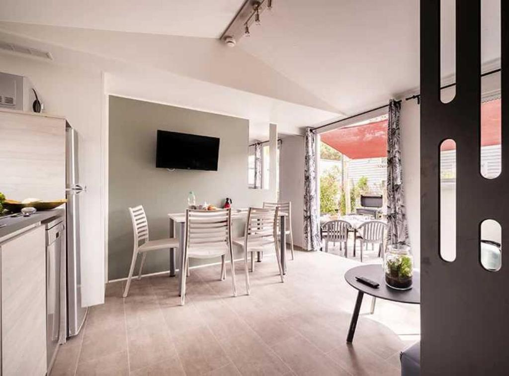 une cuisine et une salle à manger avec une table et des chaises dans l'établissement Camping 4 étoiles - Parc aquatique - ccaffga, au Cap d'Agde