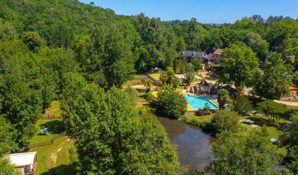 une vue aérienne d'un complexe avec piscine et arbres dans l'établissement Camping Aqua Viva, à Carsac-Aillac