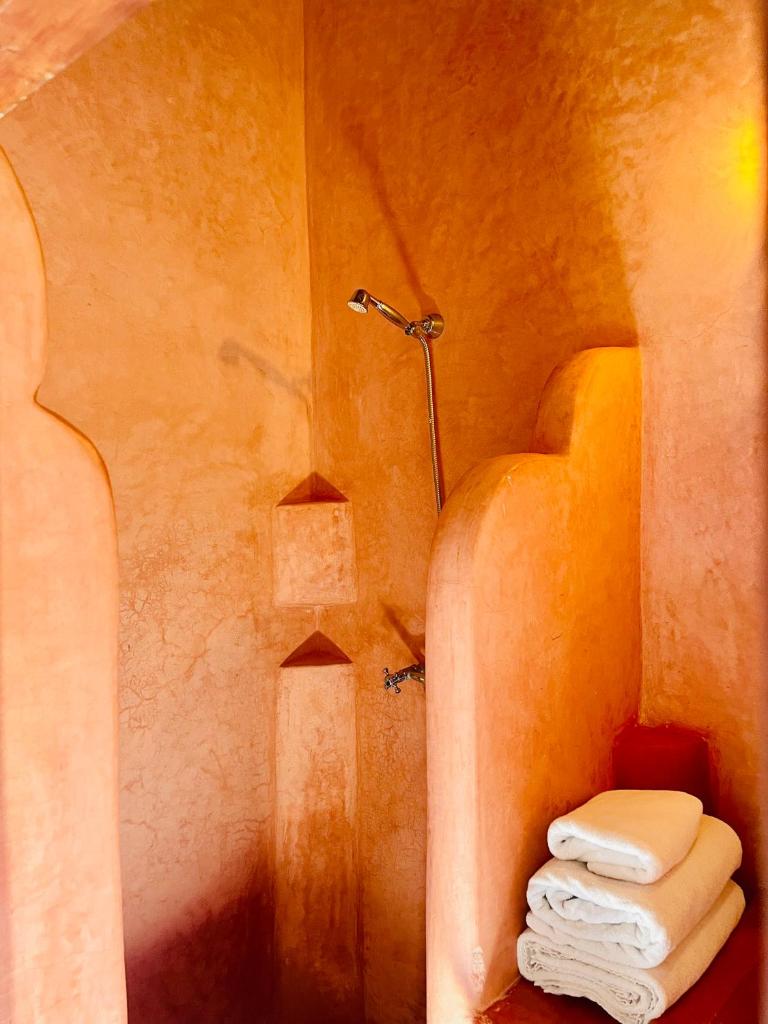 La salle de bains est pourvue d'une douche et de serviettes. dans l'établissement Riad Zarka By La Siredrah, à Marrakech
