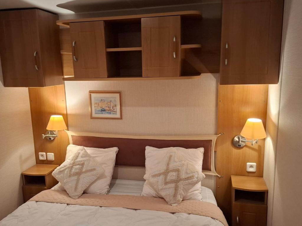 une chambre avec un lit avec deux oreillers dans l'établissement Mobilhome paisible et verdoyant, à Puget-sur Argens 37 autres photos