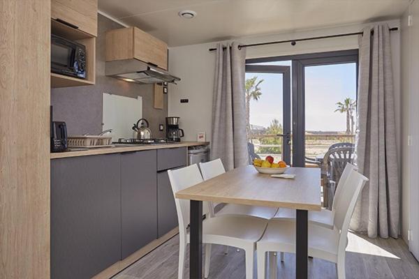 une cuisine avec une table et des chaises et une cuisine avec une fenêtre dans l'établissement Camping Clos Cottet, à Angles