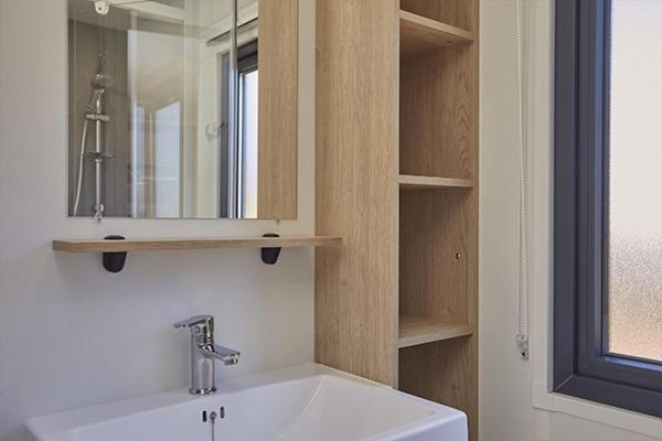 une salle de bain avec un lavabo blanc et un miroir dans l'établissement Camping Clos Cottet, à Angles