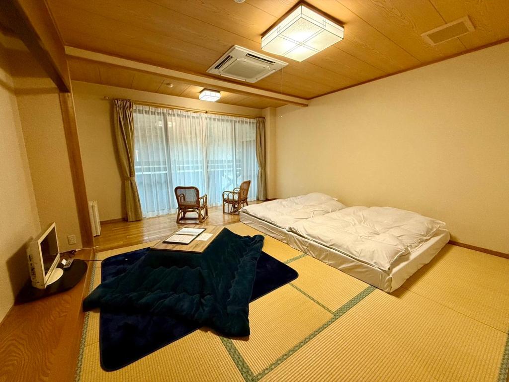 une chambre avec un lit, une table et des chaises dans l'établissement 鬼無里の湯 ホテル&コテージ, à Nagano