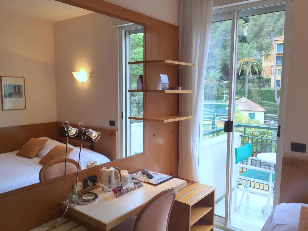 Cette chambre comprend un bureau, un lit et une fenêtre. dans l'établissement Best Western Regina Elena, à Santa Margherita Ligure