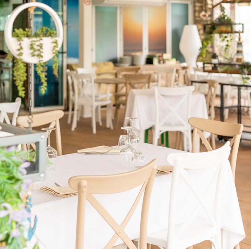 une salle à manger avec des tables et des chaises blanches dans l'établissement Hotel Sirena - B&B, à Cesenatico