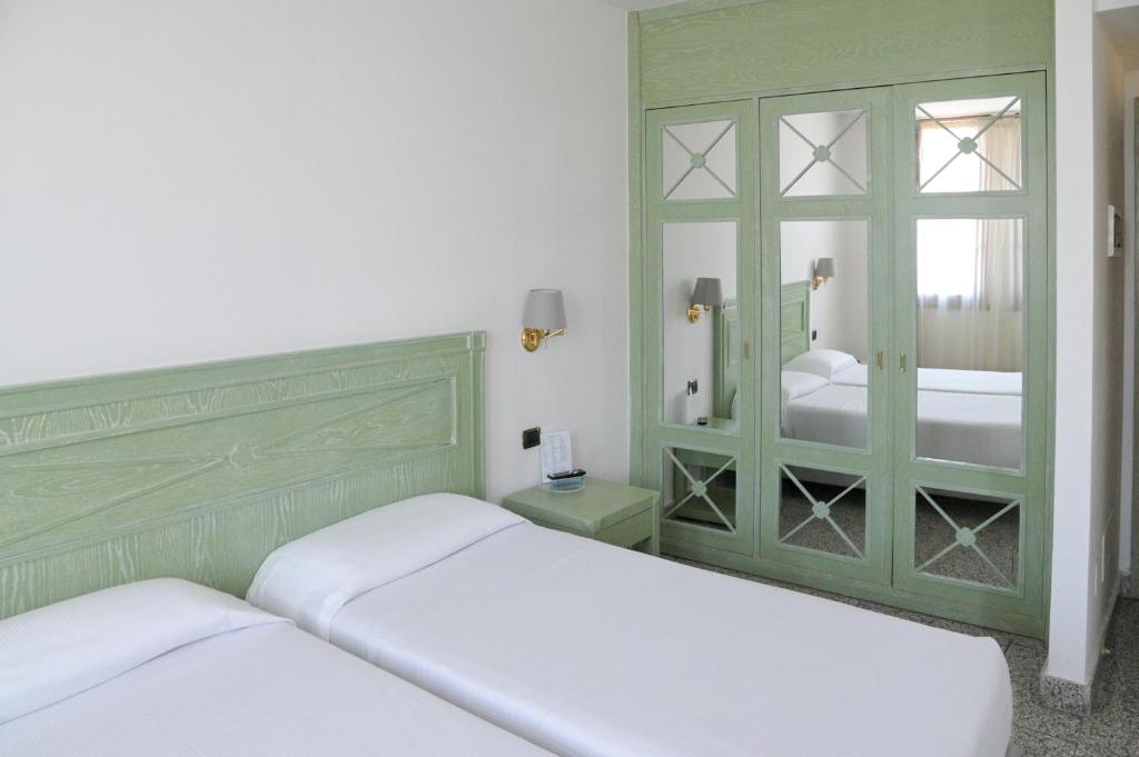 une chambre avec deux lits et un miroir dans l'établissement Residence Hotel L'incanto Di Boccadarno, à Marina di Pisa