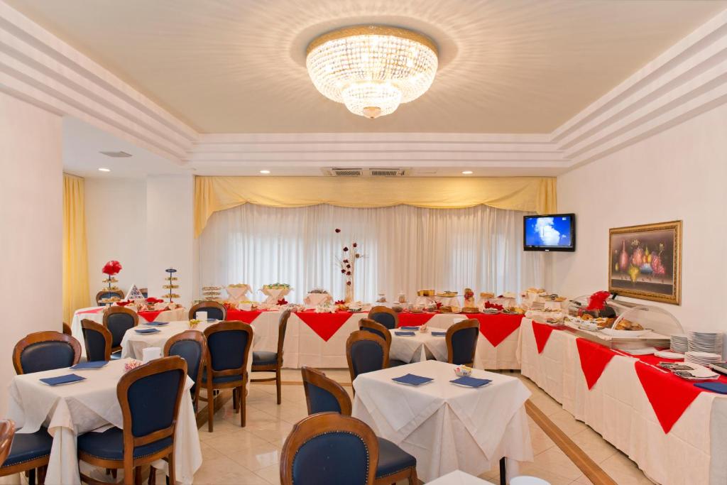 une salle de banquet avec des tables et des chaises et une télévision dans l'établissement Hotel City, à Montesilvano