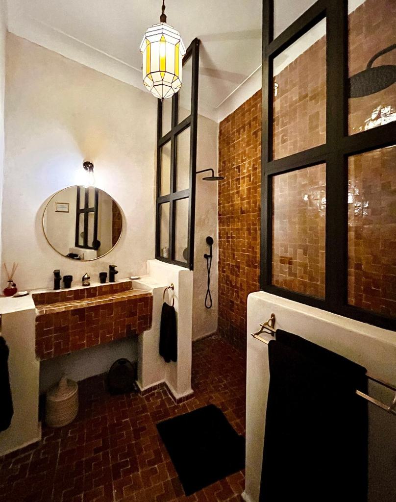 une salle de bain avec un lavabo et un miroir dans l'établissement Dar Titrit, à Marrakech 37 autres photos