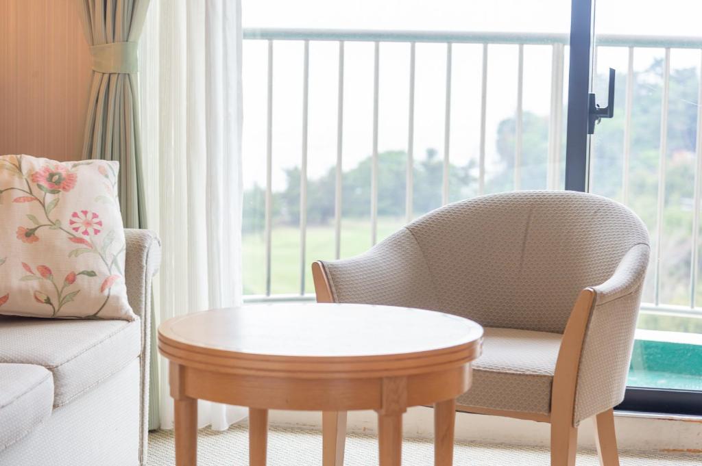 - un salon avec une chaise et une table basse dans l'établissement Onahama Ocean Hotel & Golf Club, à Iwaki
