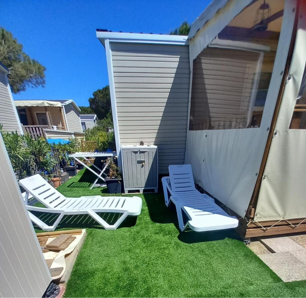 un jardin avec deux chaises longues et un kiosque dans l'établissement Mobil home tout équipé, Camping 4 Etoiles, plage à 100m, à Canet