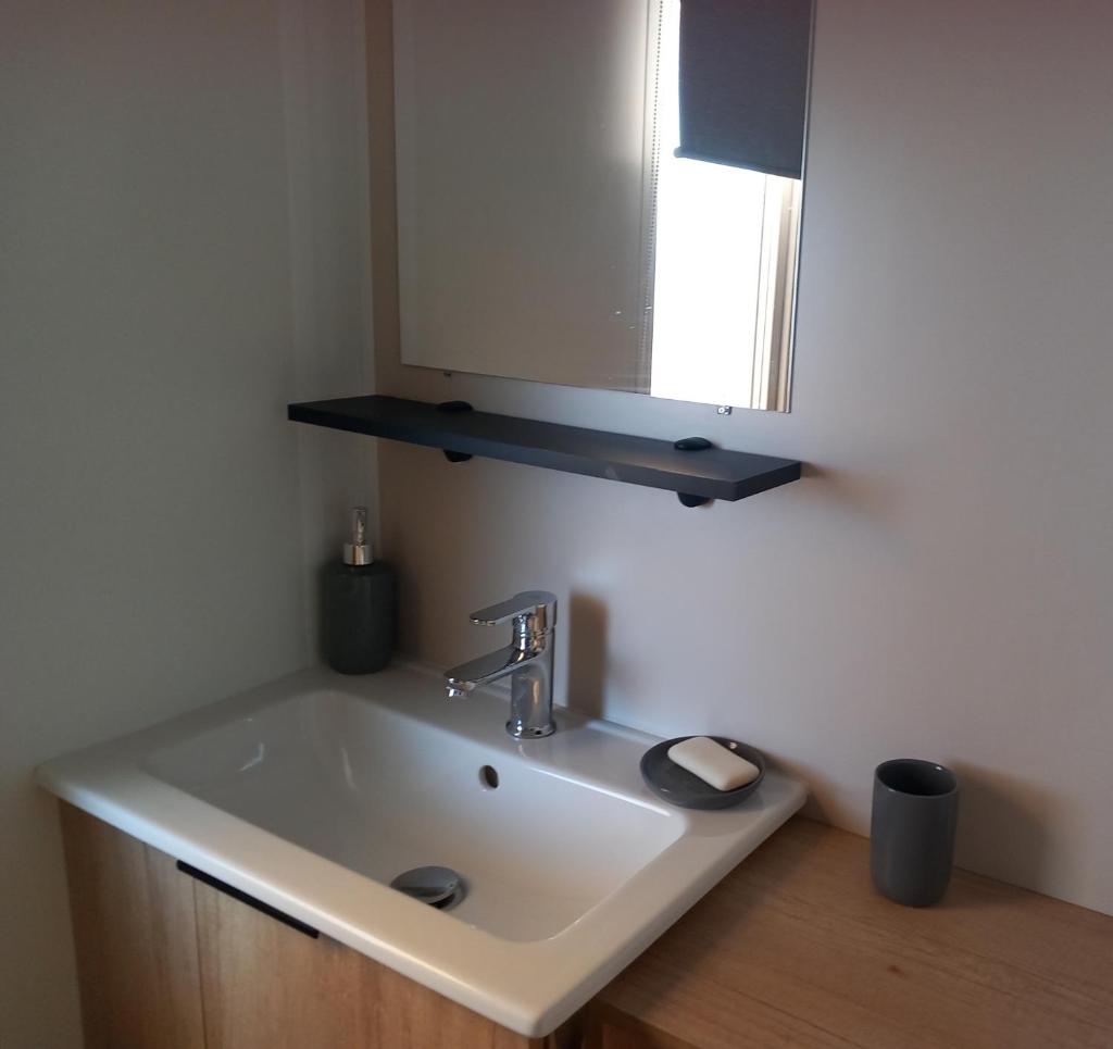 une salle de bain avec un lavabo et un miroir dans l'établissement Mobil home tout équipé, Camping 4 Etoiles, plage à 100m, à Canet