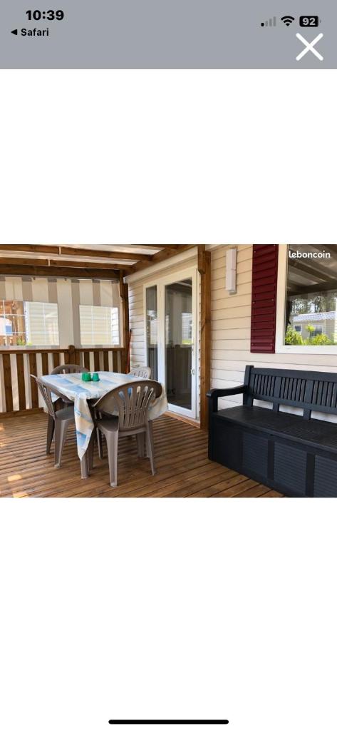 d'une terrasse couverte avec une table et des bancs. dans l'établissement Mobilhome 6 et 4 places terrasses couvertes - Les Dunes de Contis, à Saint-Julien-en-Born