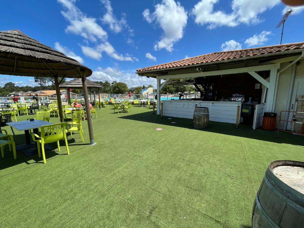 d'une terrasse avec des tables et des chaises sur une pelouse. dans l'établissement Natuara - L'horizon du lac - Wifi inclu, à Gastes