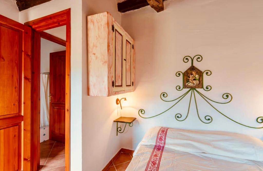 une chambre avec un lit et un miroir au mur dans l'établissement Lu Stazzu di Tarraolta, à Vignola Mare 16 autres photos