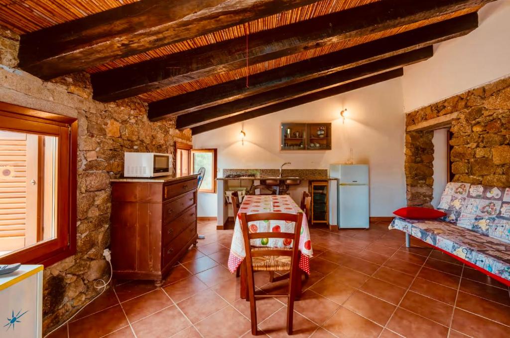 une cuisine et un salon avec une table et un canapé dans l'établissement Lu Stazzu di Tarraolta, à Vignola Mare